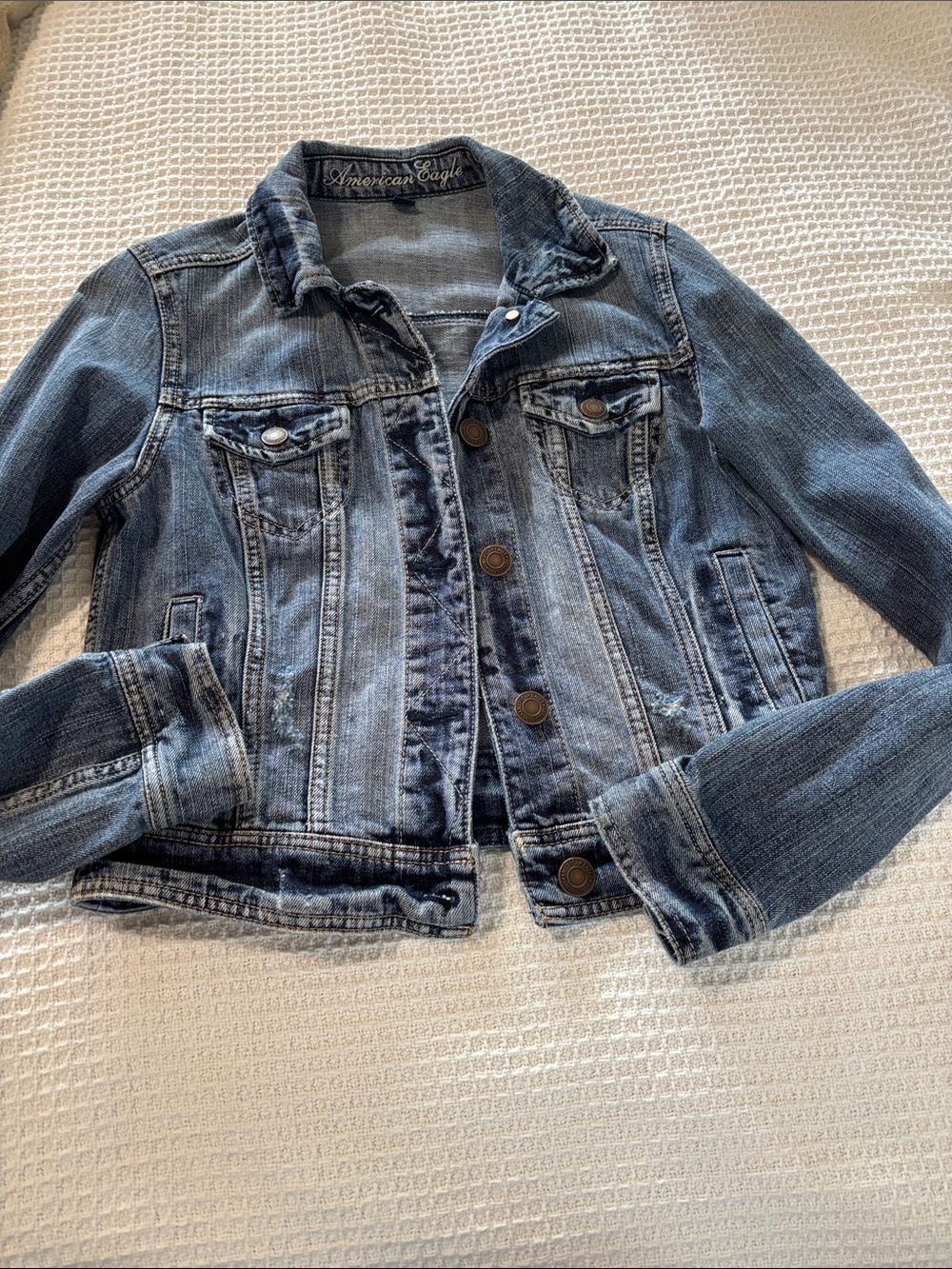 This American Eagle denim jacket features a light wash and distressed details.